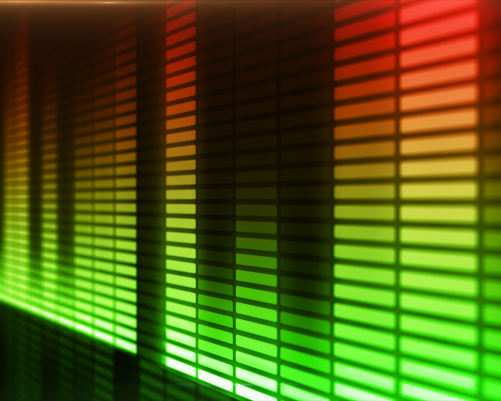 Close-up of a digital audio equalizer display showing vertical LED-style bars at varying heights. The bars transition from green at lower levels through yellow to red at peak levels, creating a classic volume meter visualization against a dark background.