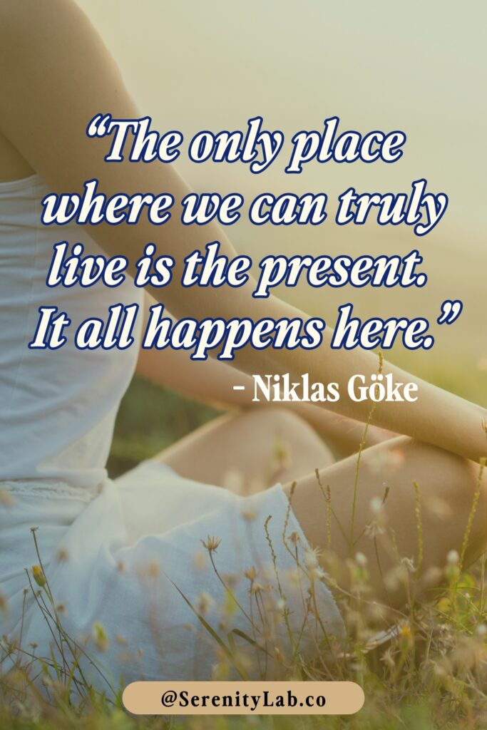 A person in white clothing sitting in a meditation pose in a sunlit field of wildflowers, with "The only place where we can truly live is the present. It all happens here." – Niklas Göke.